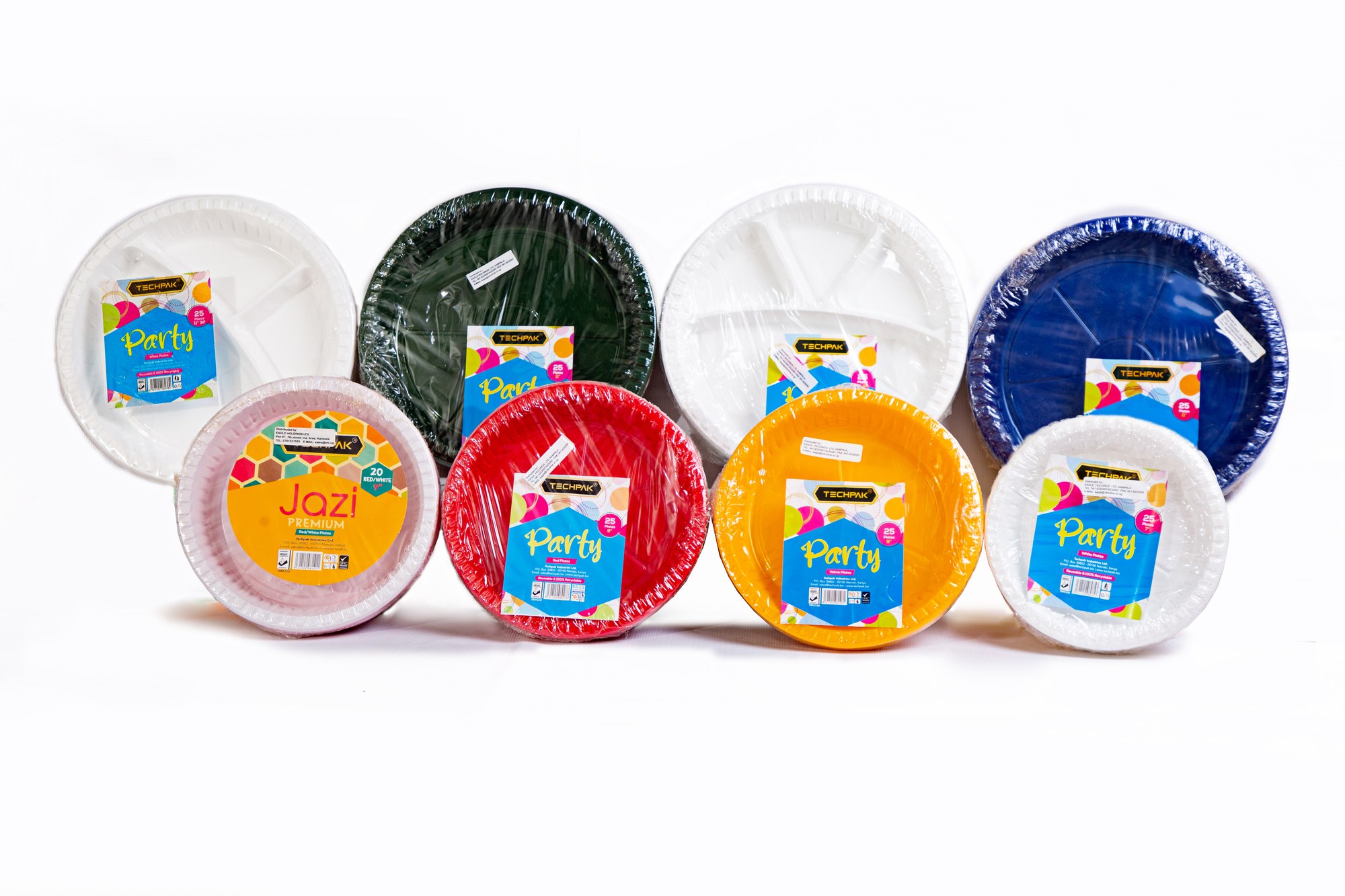 Techpak plate range on retail shelves — round and partitioned plates in white, yellow, green, blue and red, plus Jazz Celebration packs